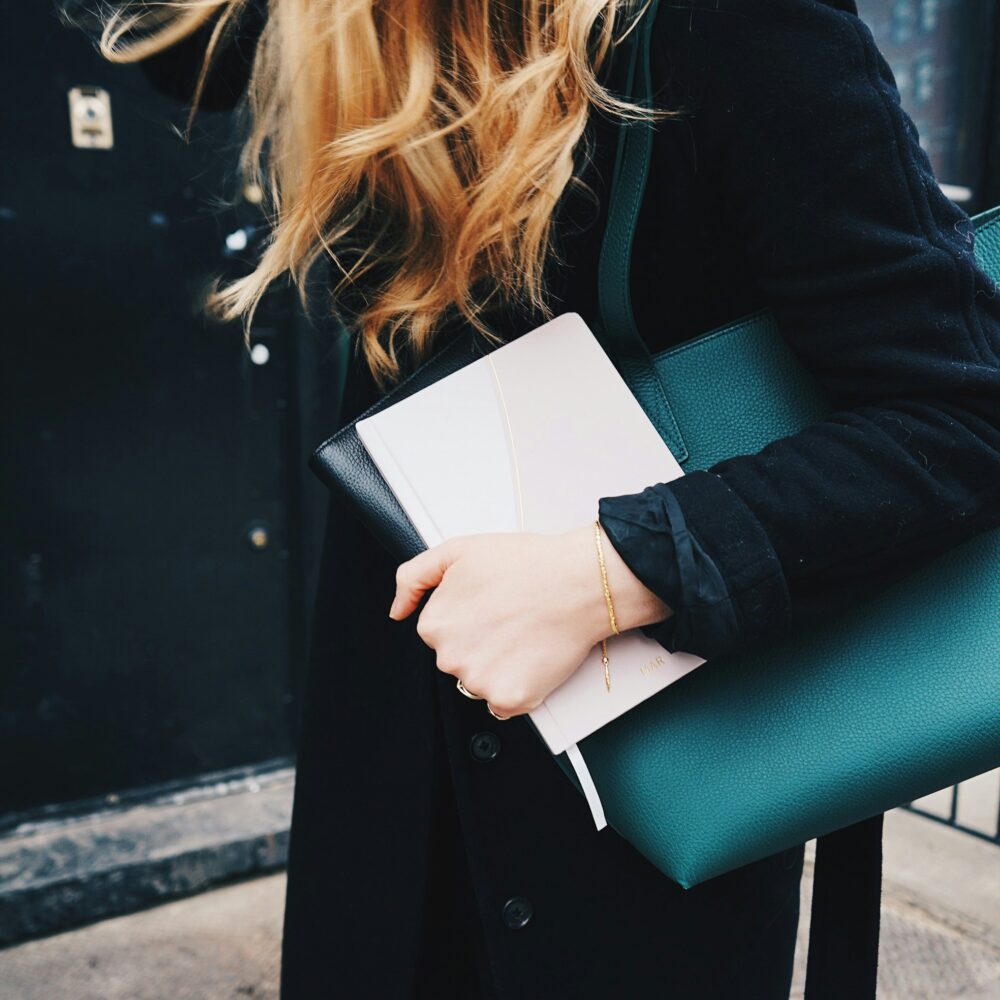 Business Woman in the streets with green bag and notebook